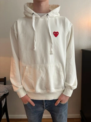 Vit hoodie från Comme des Garçons - Säljer en vit hoodie från från Comme des Garçons med det klassiska röda hjärtat. Helt oanvänd och säljer den för endast 499kr!