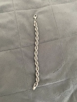 Flätat silverarmband 925 äkta - Snyggt armband i äkta silver (925) med flätad design och karbinlås.Den är köpt ifrån kejsar för 1700kr Armbandet har en stilren och tidlös look som passar perfekt till din vardagsstil. Perfekt accessoar för dig som gillar klassiska smycken i silver.