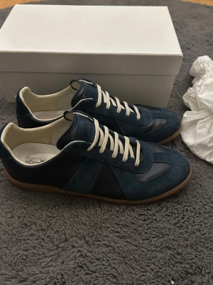 Maison Margiela skor  - Säljer dessa sjukt feta mörkblåa maison margiela skorna som är i ett hyfsat bra skick. Storlek 45. Box och sånt medföljer inte tyvärr. (Endast skorna) Men hör av dig vid minsta lilla fundering! Bilderna är däremot lite äldre så skorna är lite mer slitna nu. Skriv så visar jag!