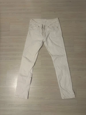 Vita slim fit jeans från Boomerang - Snygga vita slim fit jeans med klassisk femficksdesign och dragkedjegylf. Perfekta för en clean och fräsch look, passar till det mesta och är lätta att styla. Materialet känns mjukt och stretchigt för extra komfort. Stl 29/32, modell Elsa