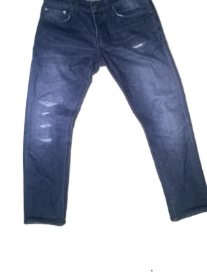 Gråa dondups - Säljer ett par gråa dondup jeans med slimad ben och slitna detaljer på framsidan. Jeansen är i storlek 31 och har ett ihop lagat hål där bak men syns inte vid avstånd(kolla sista bilden).