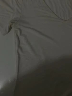 Vit basic t-shirt med v-ringning - En enkel vit t-shirt med v-ringad hals och korta ärmar. Perfekt till alla outfits och lätt att matcha. Tillverkad i mjukt bomullsmaterial för skön känsla hela dagen.