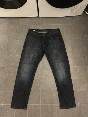 Jack & Jones Tapered Mike  - Säljer ett par Tapered Mike från Jack & Jones. Jeansen är straight fit och storleken är: W: 33 och L 32 men sitter lite mindre i midjan än 33.
