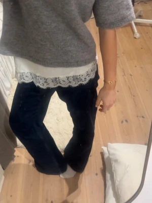 Mörkblå vida jeans - Säljer ett par mörkblå jeans med vid passform och klassisk femficksdesign. Jeansen har låg/normal midja och är tillverkade i ett mjukt denimtyg som ger en avslappnad look. Perfekta till en enkel topp eller stickad tröja.