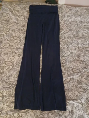 Mörkblå utsvängda mjukisbyxor - Säljer ett par mörkblå yoga pants från gina trikå Byxorna är i mjukt och stretchigt material, . Passar dig som gillar bekväma och stilrena plagg. Kan sjika fler bilder vid förfrågan 