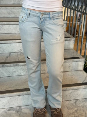bootcut jeans med spets - Säljer dessa perfekta ljusblå lågmidjade-bootcut jeans med hål på framsidan och spets där nere😍💗