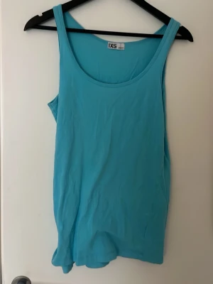 Turkos linnetopp i bomull XS - Snygg turkos linnetopp i storlek XS med klassisk rund halsringning. 