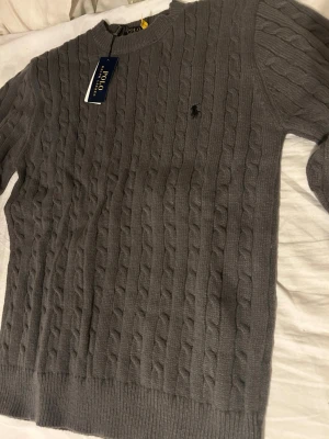 Grå ralph lauren tröja - Stickad ralph lauren tröja med svart logo. Helt ny, oanvänd. Storlek S. 