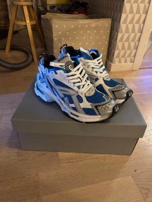 Blå och vita Balenciaga sneakers - Säljer ett par helt nya Balenciaga runner i färgen blå och vitt dem är inte äkta men 1:1 som man ser på bilderna. Dem är aldrig andvända. Jag säljer dem pågrund av fel storlek. Allting ingår box, dustbag, kort och extra snören. Pris kan diskuteras!!