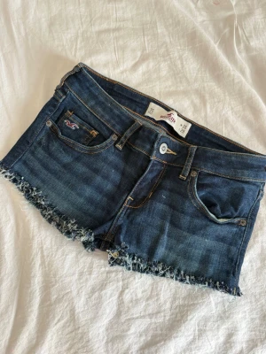 Mörkblå jeansshorts från Hollister - Snygga mörkblå jeansshorts från Hollister!! Snygga detaljer på fickorna🥰🥰 W26💕 midjemått rakt över är ca 32cm🥰🥰