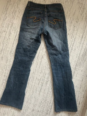 Bootcut jeans från EDC Esprit - Säljer mina grå/blå bootcut jeans från EDC Esprit. Byxorna är lågmidjade och har ett sjukt snyggt mönster på bakfickorna. Jag har för många jeans så tyvärr behövde dom här ryka. Jeansen har använts en hel del men är hela och i bra skick! Storleken är ca XS men kan också passa en liten S🩷