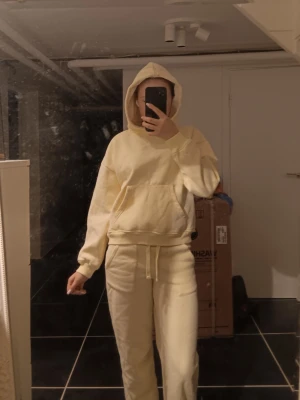 Ljusgult mjukisset - Säljer ett par ljusgula mjukisbyxor med resår och ljusgul hoddie. Byxorna har raka ben och är gjorda i mjukt bomullsmaterial. Perfekta för en avslappnad och chill stil. Säljer som ett sett, men kan diskuteras pris om man inte vill köpa sett. Har bara används 1 gång