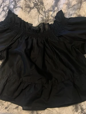 Svart offshoulder blus med volang - Hej,säljer nu min jättefina blus tveka inte på att höra av dig om du är intresserad eller har frågor!!