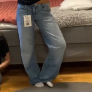 Blåa baggy jeans  - Säljer ett par mellanblåa lösa jeans från stradivarius i storlek 32. Helt oanvända. 