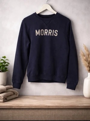 Svart sweatshirt från Morris - Säljer en stilren mörkblå sweatshirt från Morris med texten 'MORRIS' i vitt på bröstet. Tröjan har långa ärmar och en klassisk rund halsringning. Perfekt för en avslappnad look. Skick 9/10 knappast använd hör av er vid frågor och pris går att diskutera//Calle