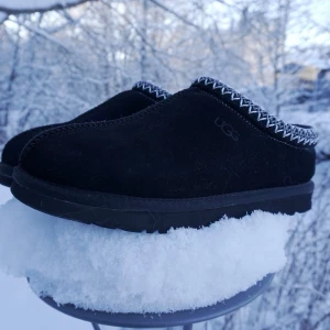 Svarta UGG Tasmans - Säljer dessa svarta UGG Tasmans i svart som passar perfekt som både inomhus- och utomhusskor nu på vintern. Insidan är fluffig och varm men passar för året om. I princip nyskick, storleken är 42🔥 Det är bara att höra av sig vid funderingar