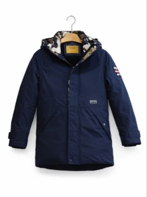 Mörkblå parkas från - Snygg mörkblå parkas från  med kamouflagemönstrat foder i huvan och patch på ärmen. Jackan har dragkedja och tryckknappar framtill, två stora fickor och justerbara muddar vid ärmsluten. Perfekt för kalla dagar och riktigt stilren.