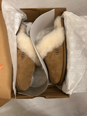 UGG Scuffette II  - UGG W Scuffette II - Inneskor. Helt oanvända, kommer i original förpackning. Köpta från Ellos för 1399kr. Pris går att diskutera men ha i åtanke att dem är helt nya och att jag redan sänkt priset med nästan 50%🫶🏼