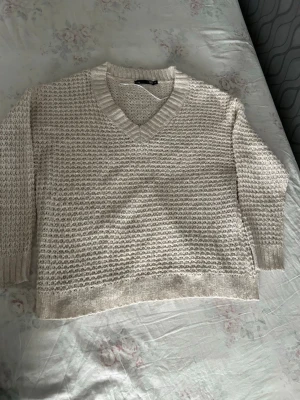 Beige stickad tröja från lager 157 - Säljer en beige stickad tröja från lager 157 med v-ringning och grovstickad struktur. Tröjan har ribbade muddar vid hals, ärmslut och nederkant. Perfekt för lager på lager och riktigt mysig att bära.