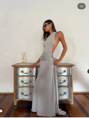 Gaia gown - Ance gria - Elegant silvergrå långklänning i oneshoulder-modell med öppen rygg och draperad midja. Från de australiensiska märket Ance gria, nypris:3660kr