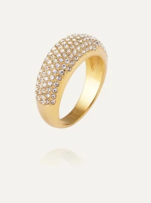 Guldfärgad ring med gnistrande stenar - Snygg guldfärgad ring från Mockberg med rundad form och tätt satta gnistrande stenar över hela ovansidan. Ringen har en lyxig känsla och passar perfekt för dig som gillar att sticka ut med accessoarer. Materialet ser ut som metall med glittrande stenar för extra bling. Ordinarie pris: 799kr