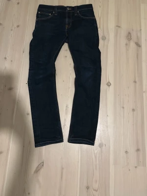 Mörkblå nudie jeans - Jag säljer mina gamla jeans för att dem är för små. Dem är w26  vilket är typ samma som storlek 164.