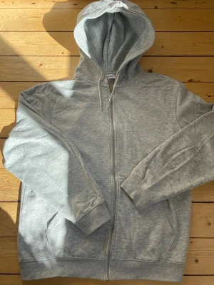 Ljusgrå zip hoodie med huva - En stilren ljusgrå hoodie från weekday med dragkedja framtill och justerbar huva. 