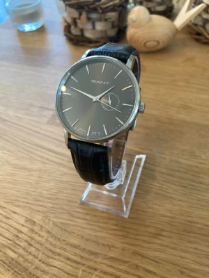 Gant Park Hill II 42mm Herrklocka - Säljer en snygg stilren herrklocka från amerikanska GANT i nyskick enligt bilder. Finns små tecken på användning som ej stör. Går bra med fungerande batteri, originalarmband i äkta läder, datumvisare, vattentät, japanskt urverk osv. Modell: Park Hill II W10841.  Nypris: 2300 SEK Mitt pris: 489 SEK  Skickas alltid snabbt och spårbart. Skriv vid frågor och se gärna mina andra annonser!   GRATIS: För betalande kunder erbjuder jag personlig experthjälp för dig att göra nya fynd (nytt & begagnat).