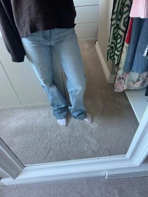 Ljusblå raka jeans - Säljer ett par ljusblå jeans med rak passform och klassisk femficksdesign. Jeansen har medelhög midja och är tillverkade i ett mjukt denimtyg som ger en avslappnad look. Perfekta för dig som gillar en enkel och tidlös stil.