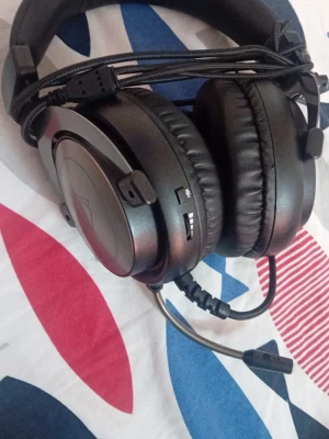 Svarta gaminghörlurar med mikrofon - Snygga svarta over-ear gaminghörlurar med vadderad bygel och stora mjuka öronkuddar. Utrustade med justerbar mikrofon och volymkontroll på sidan. Sladd med USB-anslutning och robust design, perfekta för långa spelsessioner.