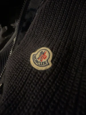 Marinblå stickad jacka från Moncler - Säljer min moncler cardigan som jag haft ett tag, passar perfekt till våren eftersom den är lite tunnare. Jackan har en smal passform och är perfekt för dig som gillar stilrena och exklusiva plagg. Passar till både hoodie och t-shirt.