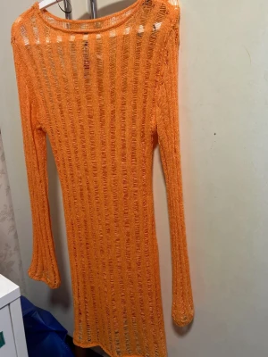 Stickad strandklänning - Oanvänd stickad strandklänning i neon orange köpt utomlands Storlek S, men passar även M och mindre L då den är väldigt stretchig i material o formar sig efter ens kropp Pris kan diskuteras vid snabb affär!