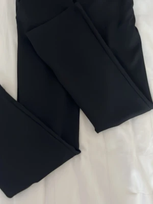 Svarta kostymbyxor  från 157 - Säljer ett par klassiska svarta kostymbyxor från 157. De har en enkel och stilren design med stretchigt material som sitter skönt. Perfekta att matcha med oversized tröjor eller hoodies. Midjemodellen är normal och tyget är mjukt och följsamt. Använda 1 gång.