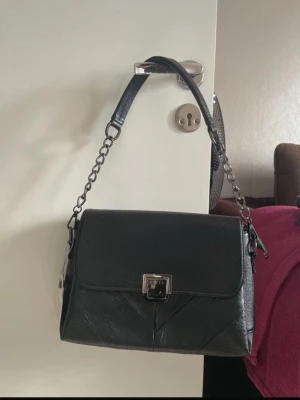 Svart Handväska - Svart handväska från märket Cinta. Innehåller tre stora fack med ytterligare två mindre fack i mitten. Väldigt praktisk! Oanvänd.