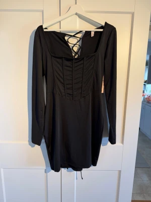 Svart kort klänning med snörning - Korsettliknande klänning med snörning baktill 