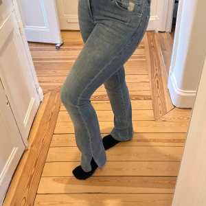 Ljusblå bootcut jeans från Frame ”Le Mini Boot” - Säljer ett par ljusblå bootcut jeans från Frame med klassisk femficksmodell och hög midja. Jeansen har en snygg tvätt och är tillverkade i mjukt denimtyg med stretch för extra komfort. Perfekta för en avslappnad och trendig look.