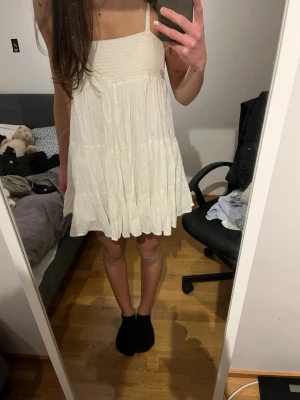 Zara vit kort sommarklänning med volang - Söt vit kort klänning med smala axelband och volangig kjol. Klänningen har en luftig passform och är tillverkad i ett lätt tyg, perfekt för varma dagar. 