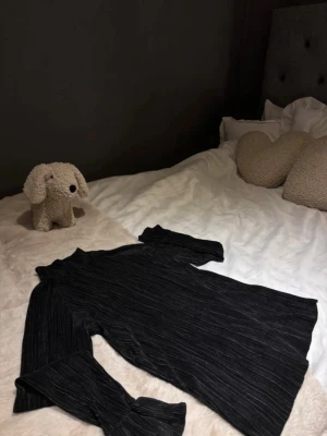 Svart ribbad långärmad topp - Säljer en jätte fin svart ribbad långärmad topp med lite högre hals, pågrund av att den inte kommer till användning. Perfekt att styla med jeans eller kjol för en clean look.