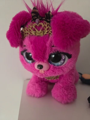 Interaktiv hund  - Söt rosa interaktiv hund med stora glittriga ögon, fluffiga öron och en guldfärgad tiara med bruna rosetter. 