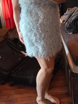 Ljusblå volangklänning - Supersöt ljusblå kortklänning med volangdetaljer över hela klänningen. Klänningen har en figurnära passform och är ärmlös, perfekt för sommarens alla tillfällen. Materialet känns lätt och luftigt.