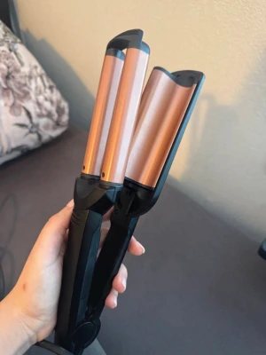 BaByliss Vågtång djupa vågor med kopparfärgade plattor - Säljer BaByliss vågtång för djupa vågor. Perfekt för att skapa snygga beach waves i håret. Tången har en enkel på/av-knapp och justerbar temperatur. Sladden är lång för smidig användning.