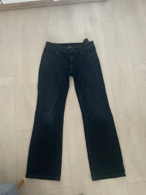 Mörkblå bootcut jeans från Zara - Säljer ett par mörkblå bootcut jeans från Zara med klassisk femficksdesign och normal midja. Jeansen har en lätt utsvängd passform nedtill och är tillverkade i denim. Perfekta för en avslappnad och trendig look. De är i storlek 36. De har två repor på baksidan som fanns redan där när jag fick jeansen.