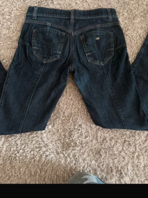 Mörkblå jeans från miss sixty - Snygga mörkblå jeans från Lee med raka ben och klassiska bakfickor. Jeansen har kontrastsömmar och Lee-logga på ena bakfickan. Tillverkade i slitstark denim som passar perfekt till din vardagsstil.innebandslängd:77 midjemått:80