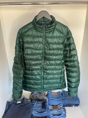 Grön dunjacka från Gant - Snygg grön dunjacka från Gant, loggan är däremot lite bortsuddad. Det finns en innerficka med dragkedja. Den är alldeles för stor för mig som är 178 cm. Hör gärna av dig vid frågor! 