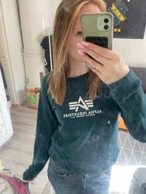 Mörkgrön Alpha Industries sweatshirt - Mörkgrön sweatshirt från Alpha Industries med vitt tryck på bröstet. Skriv vid funderingar🩷