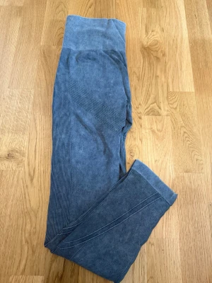 Blå sömlösa leggings med ribbade detaljer - Snygga grå leggings med sömlös design och ribbade detaljer längs sidorna och benen. Hög midja för extra komfort och stöd. Perfekta för träning eller chill dagar. Materialet är stretchigt och mjukt för bästa passform.