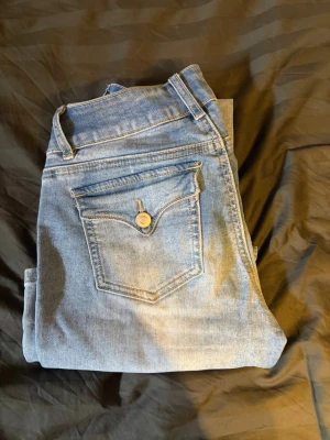 Ljusblå raka jeans från Monki - Säljer ett par ljusblå jeans från Madlady med raka/bootcut ben och klassisk femficksdesign. Jeansen har en snygg tvätt och silverfärgade knappar. Tillverkade i mjukt denimtyg som är skönt att bära. Perfekta för en avslappnad och trendig look.