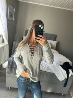 Grå ribbad tröja med snörning - Säljer en ljusgrå ribbad tröja med snygg snörning framtill i urringningen 💞