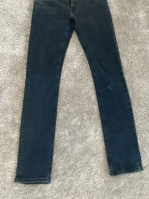 Mörkblå skinny jeans - Snygga mörkblå skinny jeans med klassisk femficksdesign och normal midja. Jeansen har smal passform hela vägen ner och är tillverkade i ett mjukt denimtyg som sitter bekvämt. Perfekta till en avslappnad streetstyle-look. 30/32