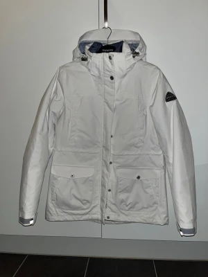 Vit skidjacka från mckinley - Skidjacka ifrån mckinley helt ny aldrig använt. Går att ta bort luvan samt ta bort innerfordret för att enbart få skalet på jackan. Jackan är liten i storlek rekommenderar mer för M/S. 
